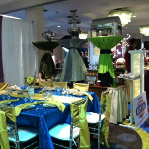 Table and chairs set up under an event tent outside