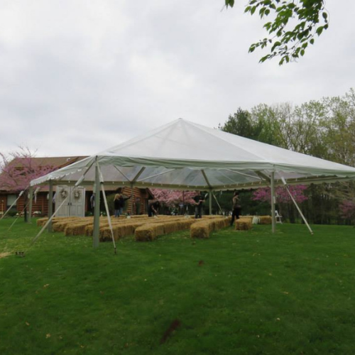 Hay bales set up under an event tent outside