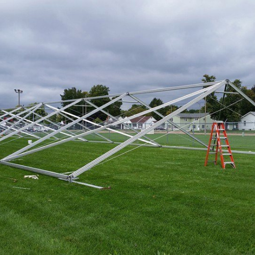 Table getting set up under an event tent outside