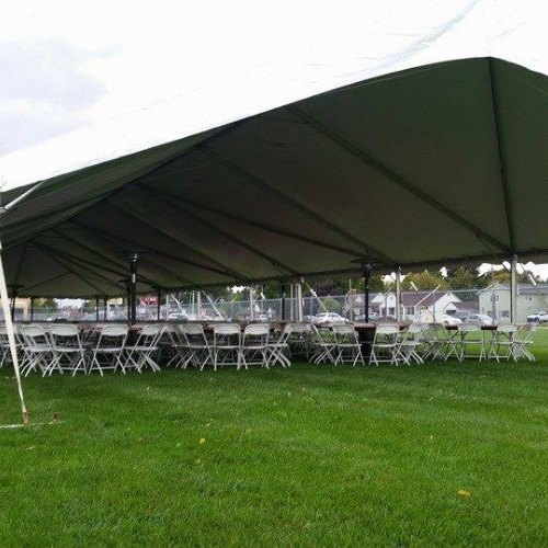 Chairs set up under an event tent outside