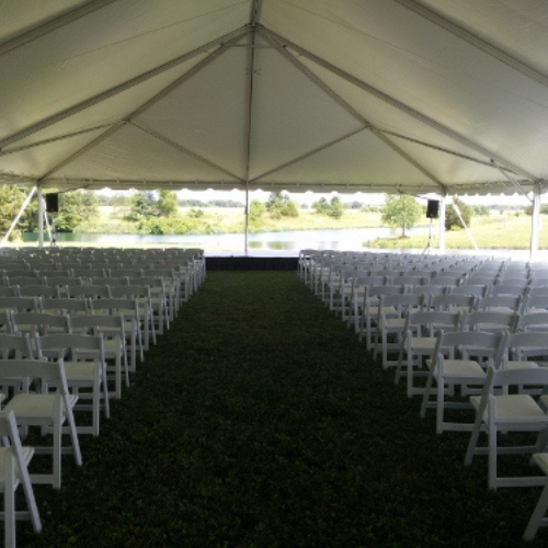 Chairs set up under an event tent outside