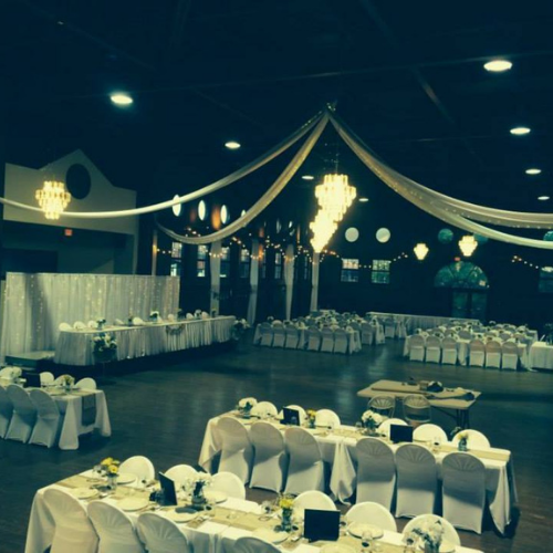 Table and chairs set up under an event tent outside