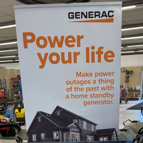 Store display with a Generac banner reading 'Power your life. Make power outages a thing of the past with a home standby generator.' Image of a house at the bottom.