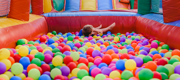 Child sliding into a ball pit